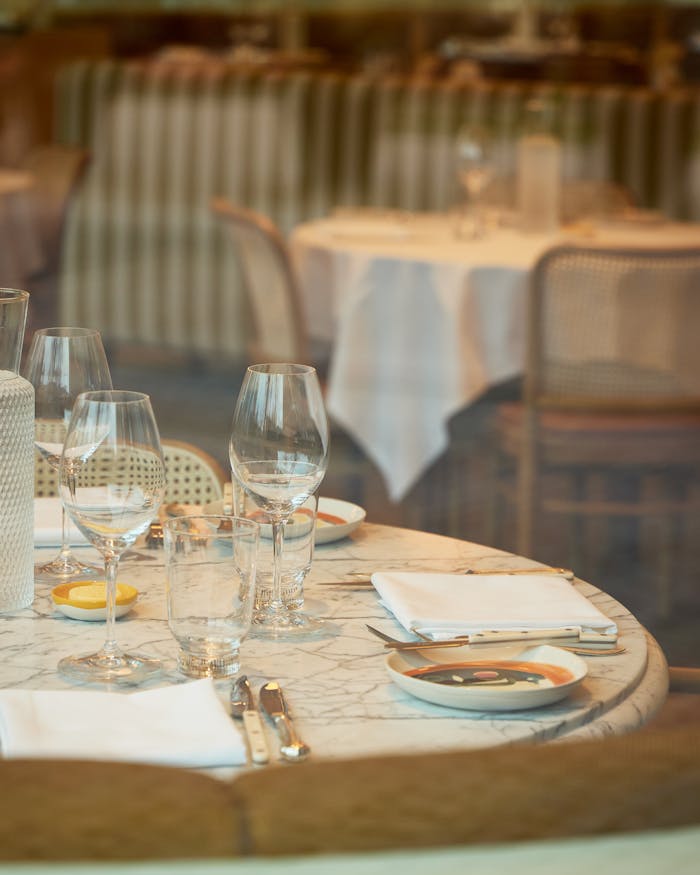 A beautifully set dining table with glassware and cutlery in a cozy restaurant atmosphere.